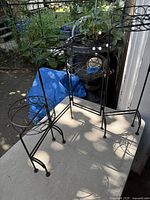 Plant stand unfolded showing four pot holders at varying heights
