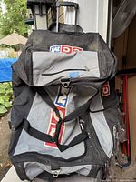 Overall view of black/grey CCM rolling sport bag showing pull handle, missing wheel