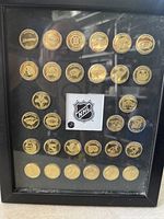 Front view of framed NHL brass coin collection showing all 30 coins and central logo