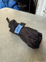 Folded compact black umbrella on tabletop