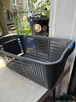 Overall view of grey plastic laundry basket on table