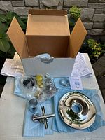Full kit in open Kohler box showing chrome escutcheon, handle, hardware and instructions