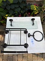 All three items laid out: glass shelf, toilet paper holder with magazine rack, towel ring