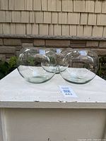 Front view of three clear spherical glass vases