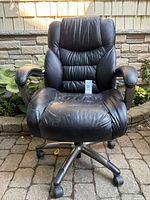 Front view of black leather office chair on casters