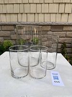 Four clear glass cylinder vases grouped