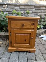 Front view of pine nightstand showing drawer and cabinet