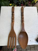 Wooden fork and spoon wall hangings displayed side by side