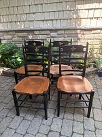 Front view of four black distressed pine chairs with natural seats