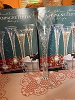 Two unopened retail boxes labeled "Champagne Flutes Set of 4" with one flute displayed in front