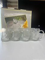 Four mugs displayed in front of original Arcoroc Magnolia box