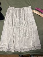 White satin half slip with lace hem displayed flat