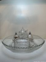 Full view of glass serving set showing plate, butter dish, honey pot, salt and pepper shakers