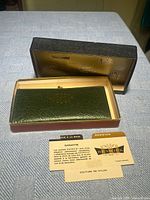 Wallet in open Renwick box with guarantee card displayed