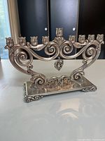 Front view showing full menorah with nine candle holders and scroll base