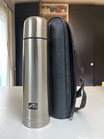 Full view of thermos standing beside zippered carry case