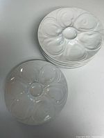 stack of six white floral motif plates