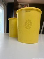 Front angled view showing both yellow canisters, floral motif and FLOUR label