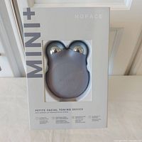 Front of sealed NuFace Mini+ box showing device window and branding