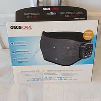 Front of retail box showing ObusForme back massager and feature list