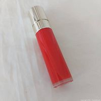 Lipstick tube standing upright showing red barrel and silver cap