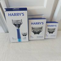 Front view of three Harry's sealed boxes: Ocean razor handle with 2 cartridges, 8-pack refills, 4-pack refills
