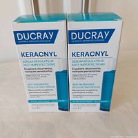 Front view of two boxed Ducray Keracnyl serums showing branding and product type