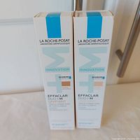 Front view of both boxed lotions showing brand, product line and shades