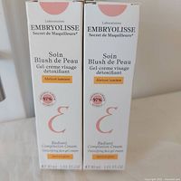 Front view of two boxed Embryolisse Apricot Glow creams, showing branding and product details