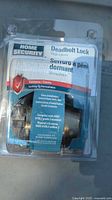 Front of sealed blister pack showing Home Security single-cylinder deadbolt lock and labeling