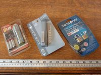 Overview of three packaged gadgets with ruler for scale