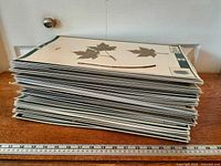 Stack of approximately 50 specimen boards with maple leaf sample visible