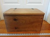 Front view of wooden chest closed showing grain and size reference ruler