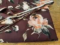 Close-up of burgundy floral stretch fabric showing print and selvage
