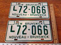 Both matching New Brunswick plates laying flat with ruler for scale