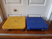 Two square dollies on table, yellow and blue