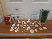 Full lot showing candle holders, box, shells, ruler for scale, vase with beads
