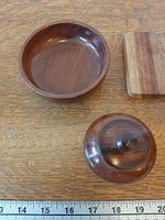 Round dish interior, lidded vessel lid removed, coaster edge, ruler for scale
