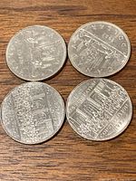 Reverse sides of the four coins showing commemorative designs