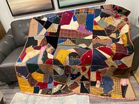 Full view of quilt draped over sofa showing size and overall pattern