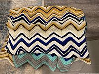 Both folded afghans showing colour palettes and ripple pattern