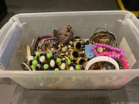 Plastic bin filled with assorted bangles and bracelets