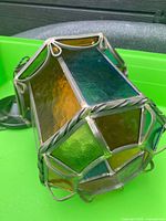 Lantern lying on side showing stained glass panels and metal frame