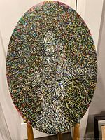 Full view of oval abstract painting on stand