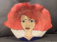Front view of plate showing entire stylized portrait and wavy rim