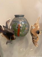 Group shot of signed pottery vase with two bone and shell carvings