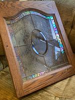 Full view of oak framed stained glass panel resting on couch