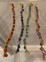 Four wire-wrapped gemstone chip bracelets laid flat