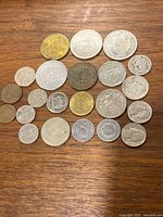 Full group of assorted coins laid out on wooden surface