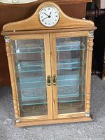 Full view of cabinet front showing clock, doors, shelves